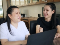 two young asian women watching attending an online meeting